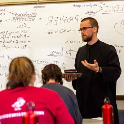 A monk teaches students in a class